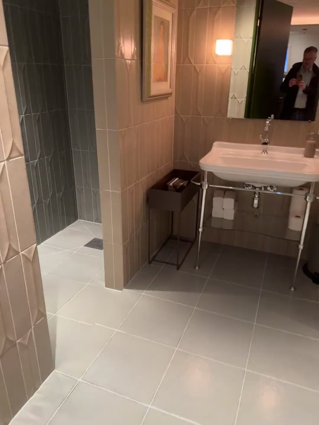 Film: dusjrommet, flislagt i grått og beige, med servant og speil