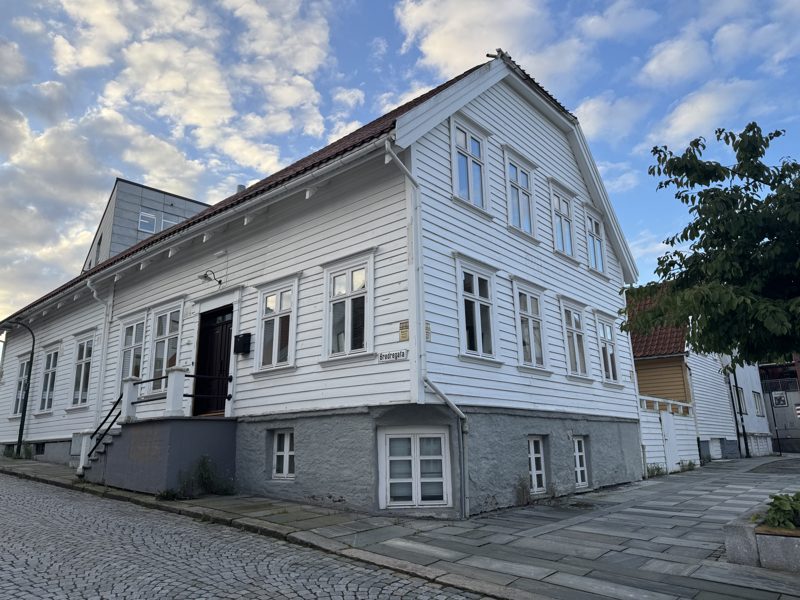 Brødregata 7: et hvitt trehus i to etasjer på et brosteinshjørne i Stavanger sentrum